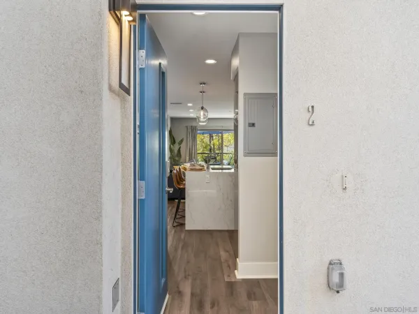 a view of a hallway with wooden floor and a bathroom