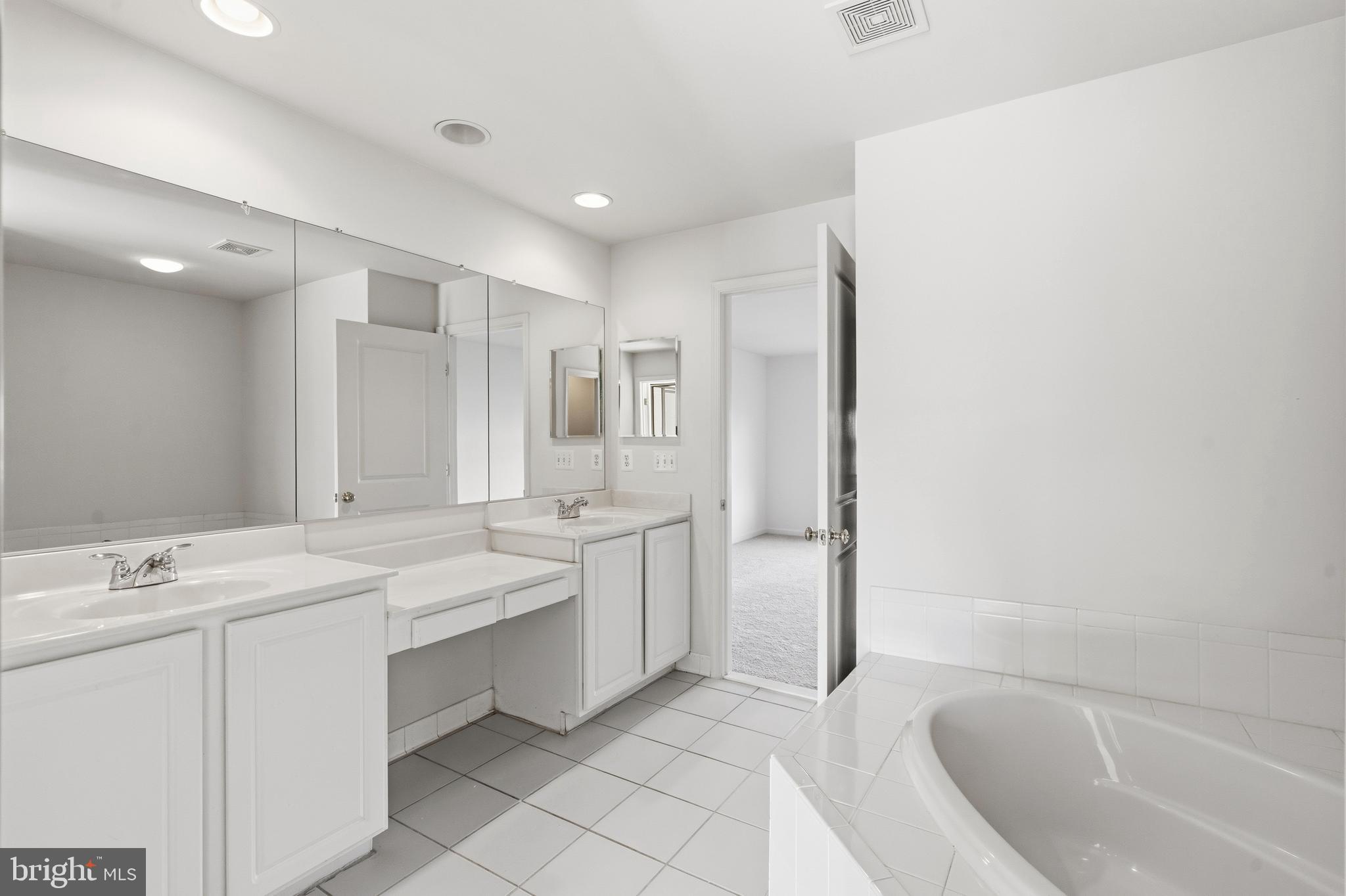9227 Ribbon Falls Loop Bristow, VA 20136 - Photo 42 of 53 a spacious bathroom with a bathtub sink mirror and toilet