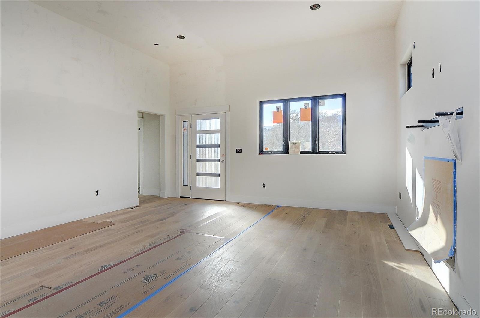 322 Two Rivers Road Salida, CO 81201 - Photo 3 of 18 wooden floor in an empty room with a window