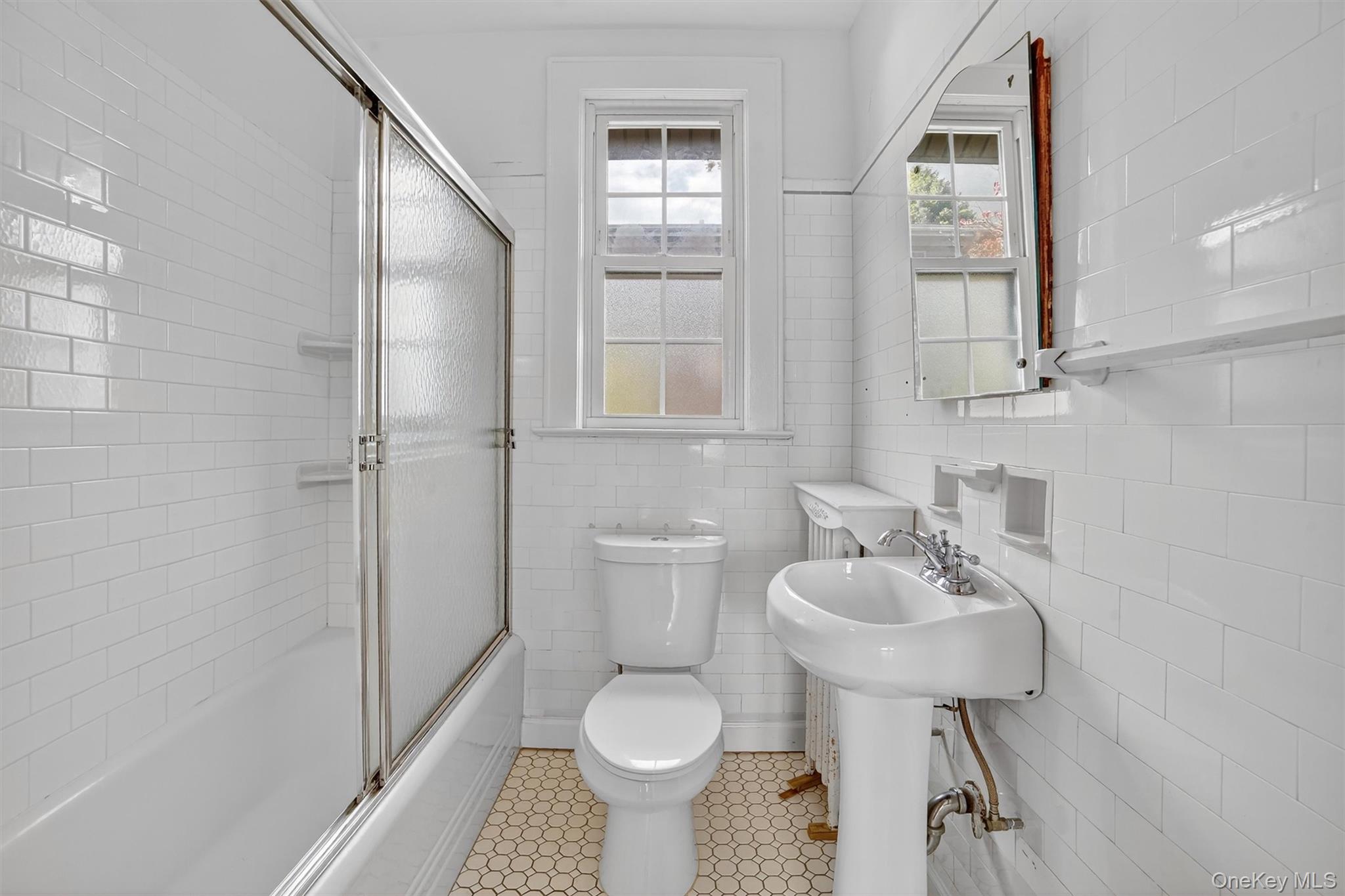 64 Elmore Avenue Croton-on-Hudson, NY 10520 - Photo 14 of 36 Full bath with enclosed tub / shower combo, tile walls, and light tile patterned floors