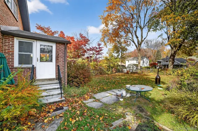 a view of a house with backyard and sitting area