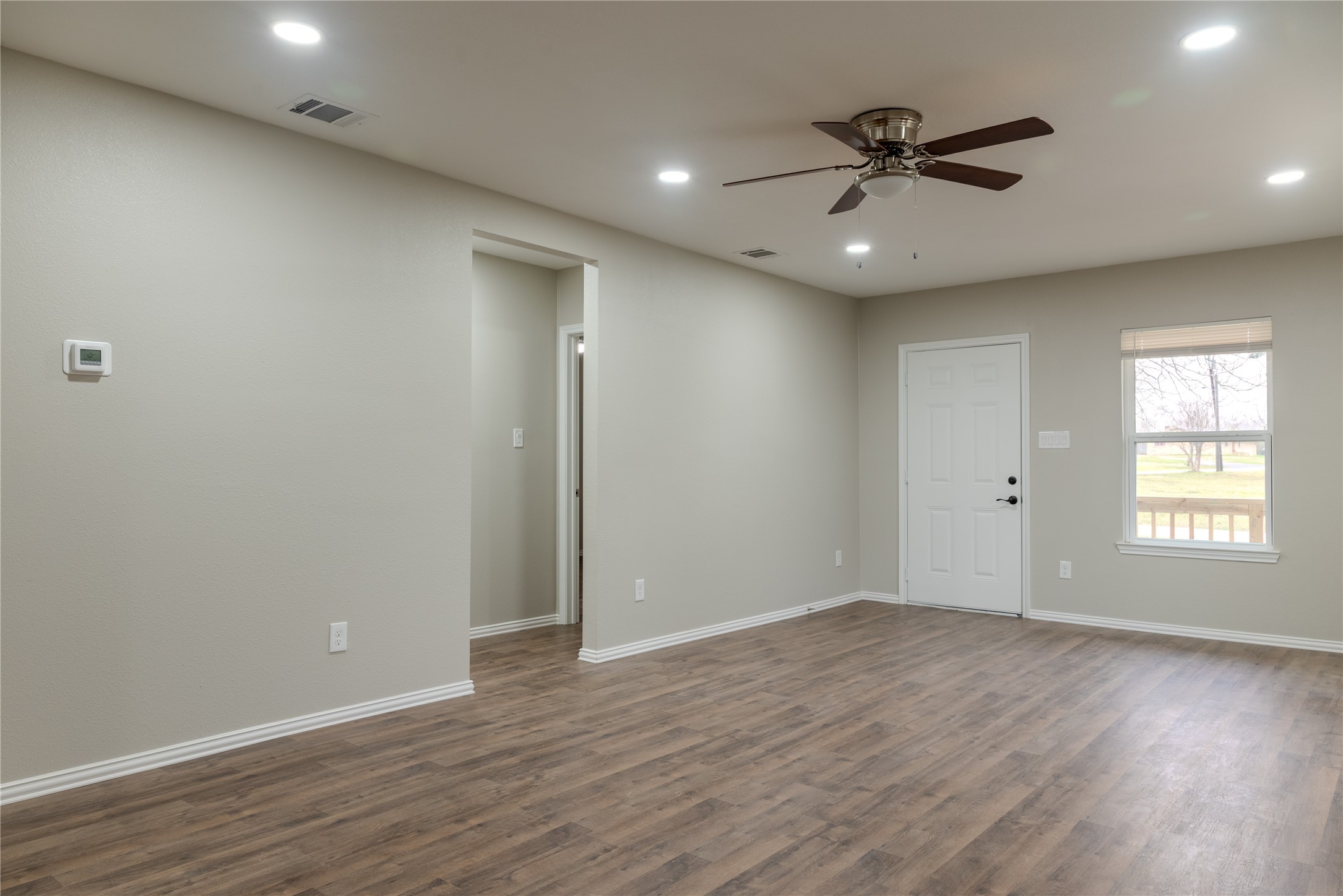 729 Planters Street Emory, TX 75440 - Photo 7 of 22 a view of an empty room with wooden floor and a window