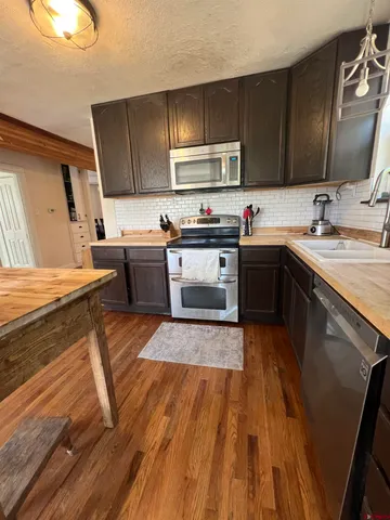 a kitchen with wooden floors and wooden cabinets