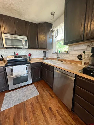 a kitchen with stainless steel appliances a sink stove and cabinets