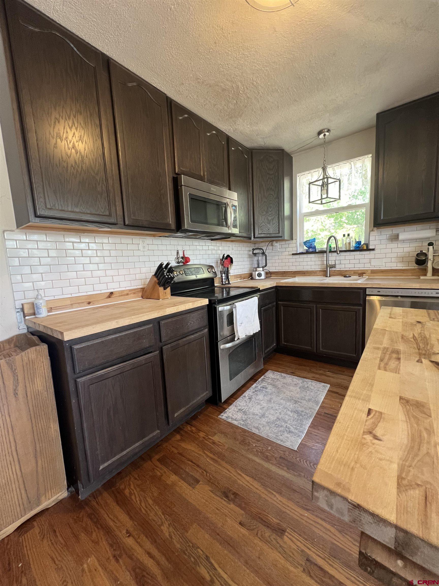 20691 Fairview Road Austin, CO 81410 - Photo 16 of 42 a kitchen with stainless steel appliances granite countertop wooden cabinets a stove top oven a sink and dishwasher