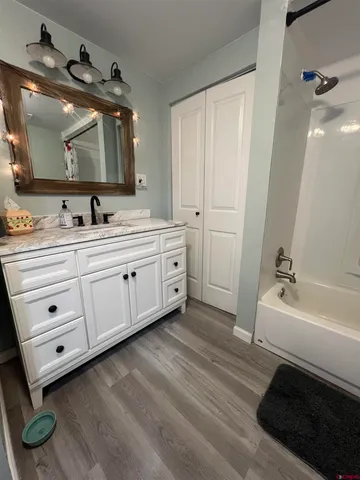 a spacious bathroom with a double vanity sink a mirror and a bathtub