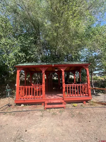 a view of a wooden house with large trees
