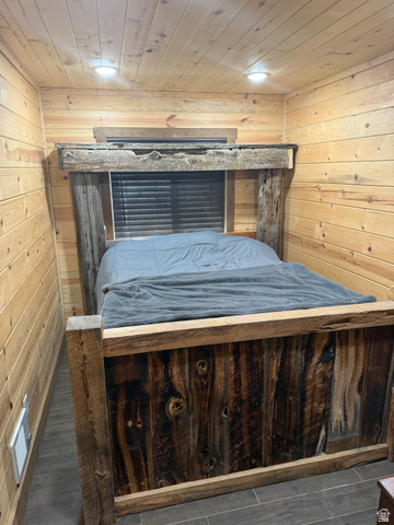 785 Hardscrabble Road Morgan, UT 84050 - Photo 14 of 16 Reclaimed wood-style bed frame, wood-paneled walls and ceiling, recessed lighting, window with blinds, and tile flooring