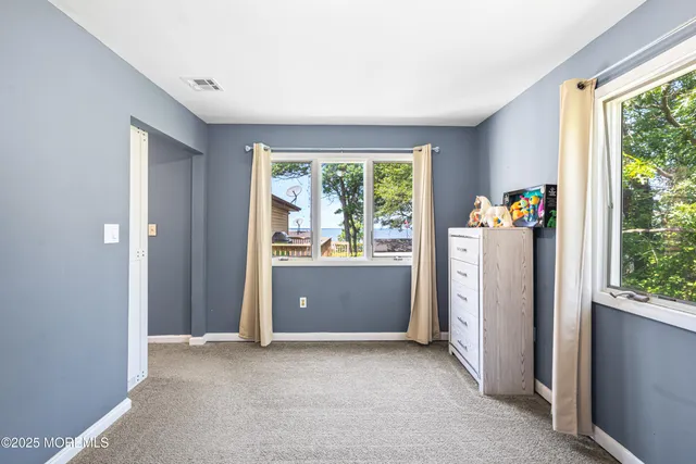 a view of a hallway with wooden floor and a bathroom