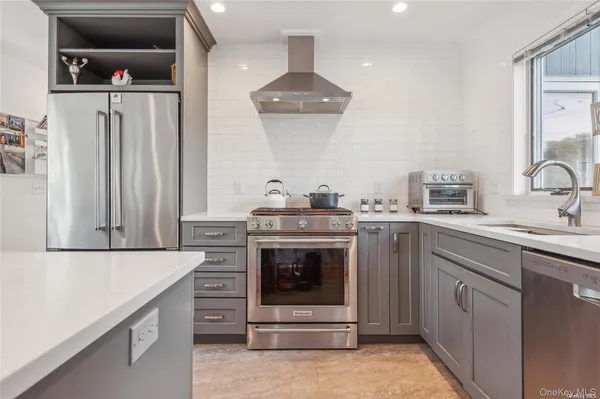 a kitchen with stainless steel appliances granite countertop a stove a sink and a refrigerator