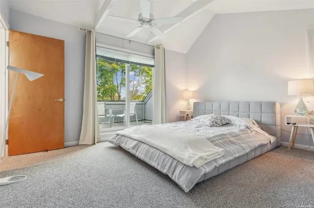 a bedroom with a large bed and a flat tv screen on dresser