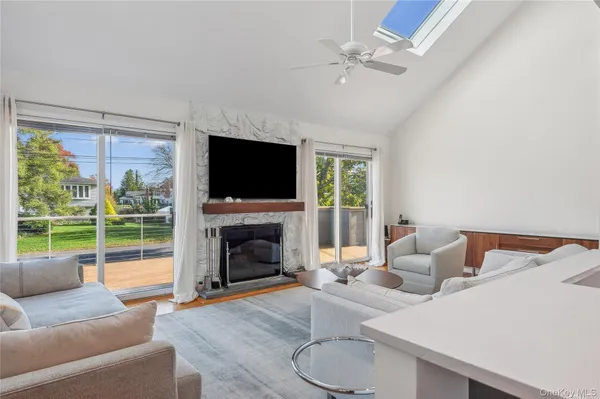 a living room with furniture a flat screen tv and a large window