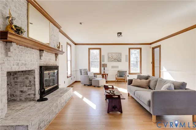 a living room with fireplace furniture and a large window