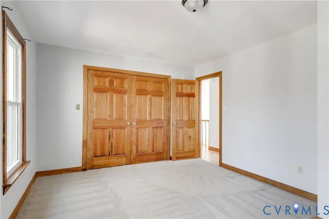 an empty room with closet and windows