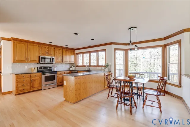 a kitchen with stainless steel appliances cabinets and a large window