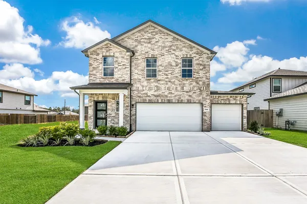 a front view of a house with a garden and plants