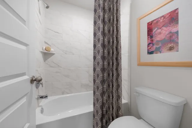 a bathroom with a toilet and a shower curtain