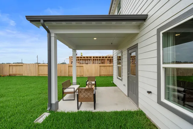 a porch with a table and chairs and potted plants by side of it