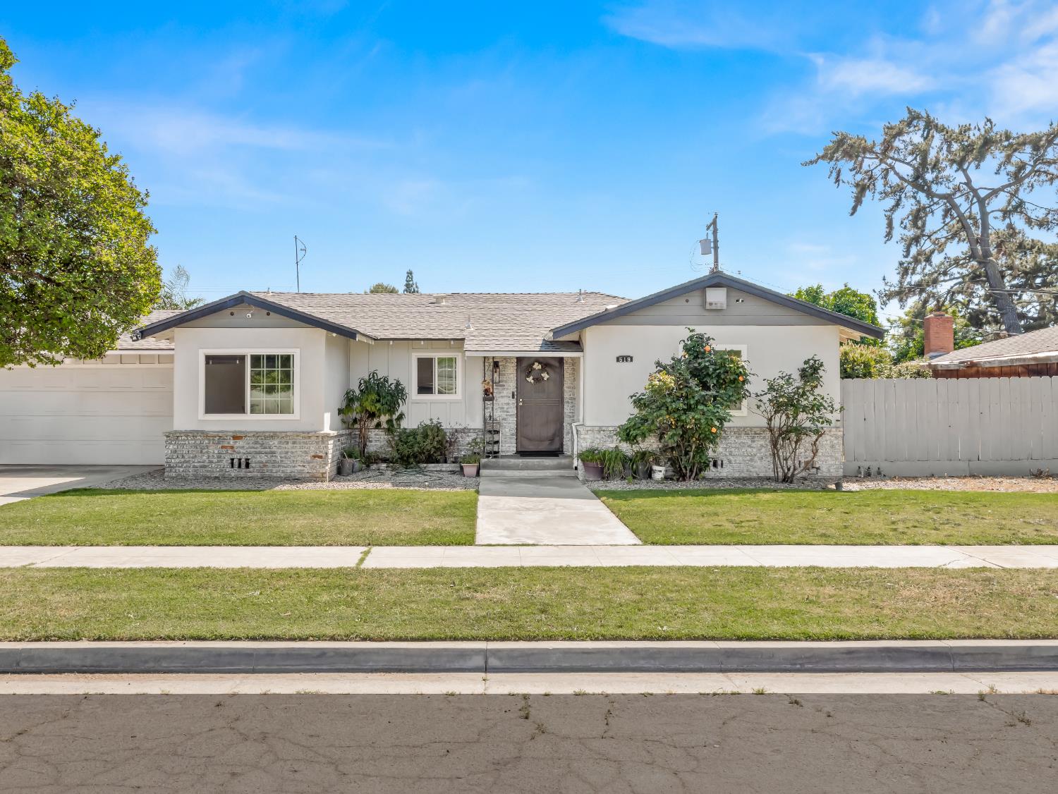 519 West Rialto Avenue Fresno, CA 93705 - Photo 2 of 36 a front view of a house with a yard and garage