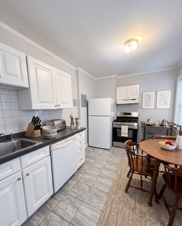 98 Strathmore Road, Unit 2 Boston, MA 02135 - Photo 6 of 11 a kitchen with a sink a table and chairs