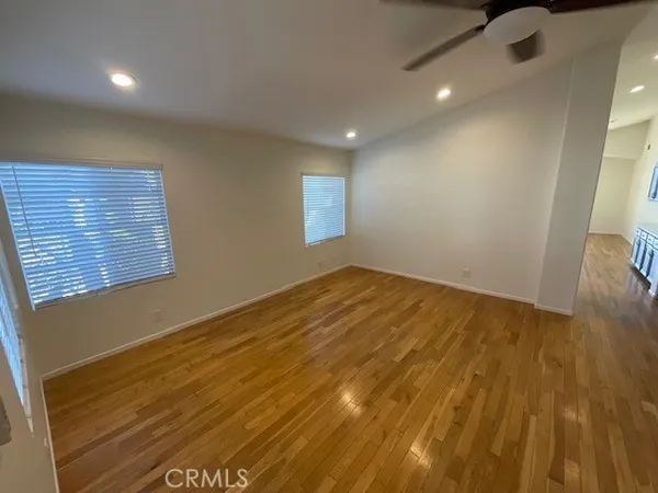 a view of empty room with wooden floor