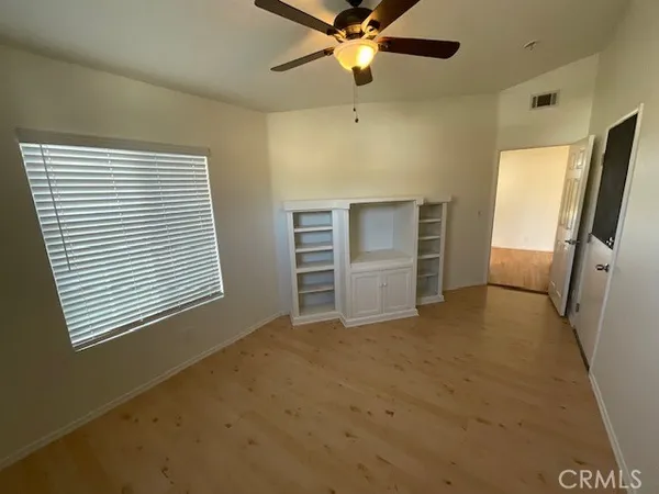 a view of a room with a ceiling fan and a window