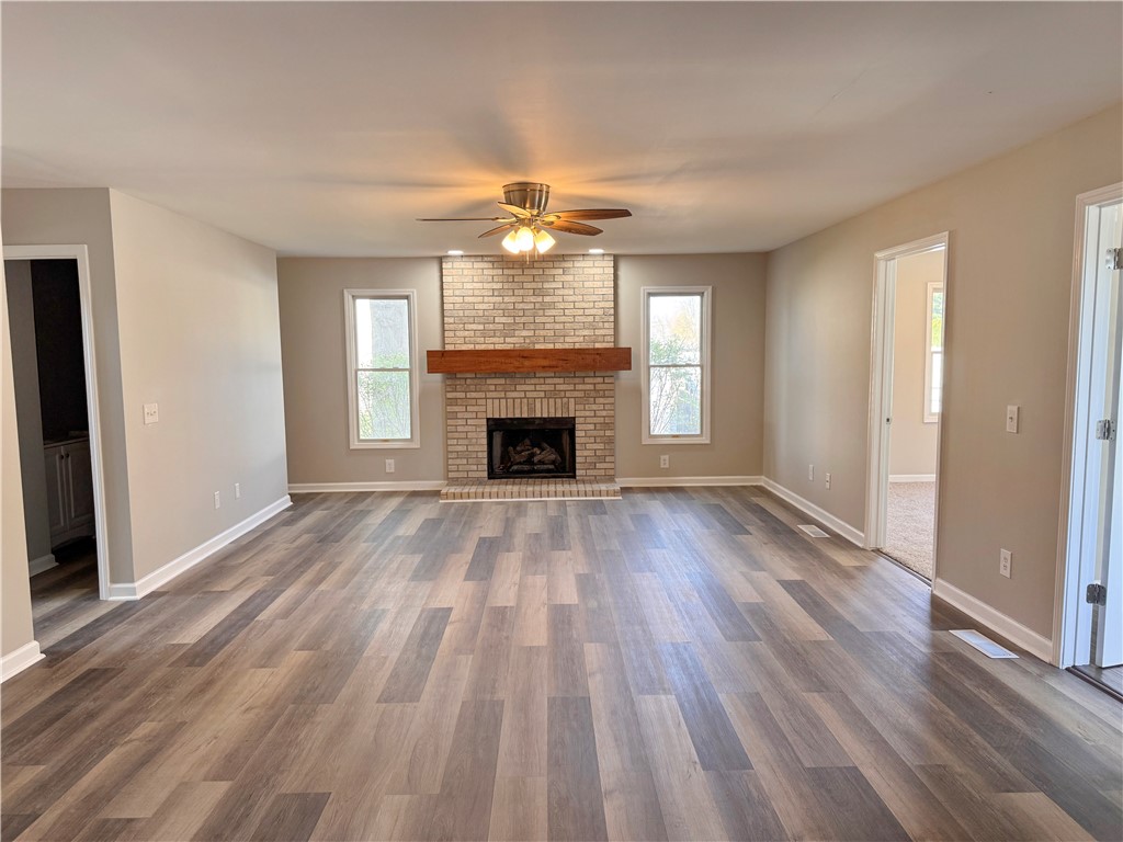 1118 Wedgewood Court Decatur, IL 62526 - Photo 9 of 22 an empty room with wooden floor fireplace and windows