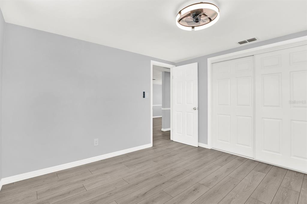 13739 Lavender Avenue Hudson, FL 34667 - Photo 11 of 25 an empty room with wooden floor and window