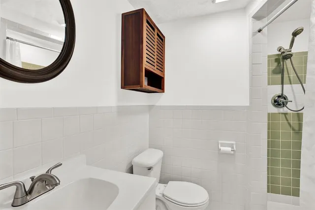 a bathroom with a sink a toilet and a mirror