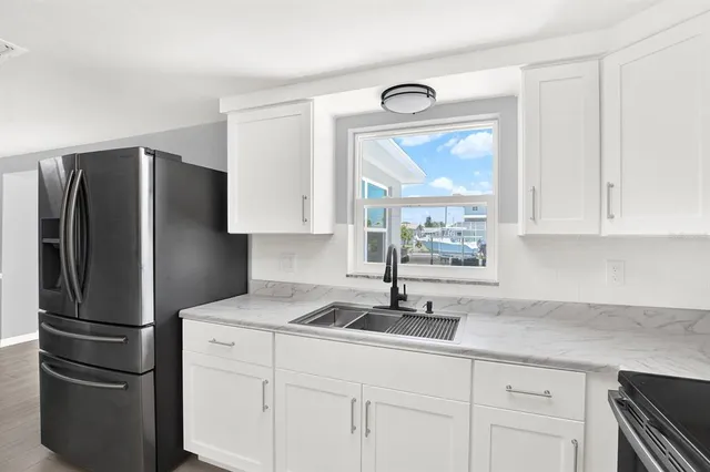 a kitchen with stainless steel appliances granite countertop a refrigerator and a sink