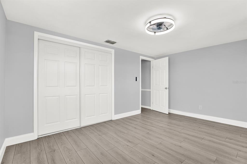 13739 Lavender Avenue Hudson, FL 34667 - Photo 7 of 25 a view of an empty room with wooden floor and a window