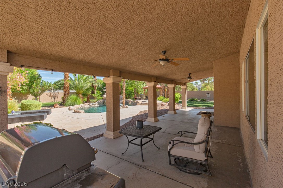 4670 Los Rancheros Avenue Las Vegas, NV 89129 - Photo 38 of 57 A spacious covered patio overlooks a sparkling backyard pool surrounded by mature palm trees.