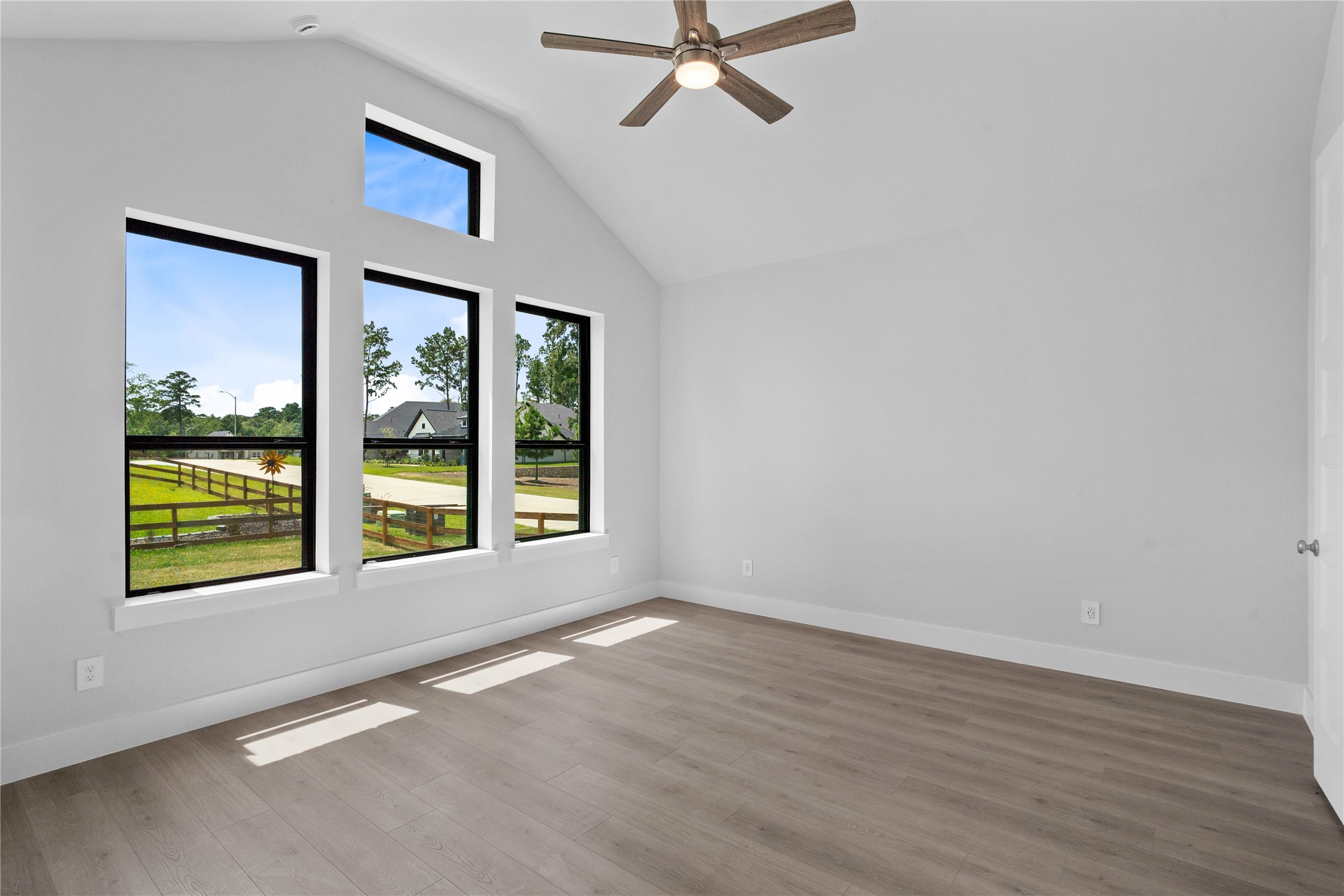 551 Black Bronco Road Magnolia, TX 77354 - Photo 28 of 50 Relax and unwind after a long day in this impressive primary suite! This generously sized room offers LVP flooring, neutral-toned paint, high ceilings with a ceiling fan, and large windows for added comfort and tranquility.