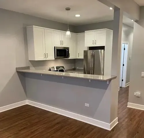 a view of a refrigerator in kitchen and wooden floor