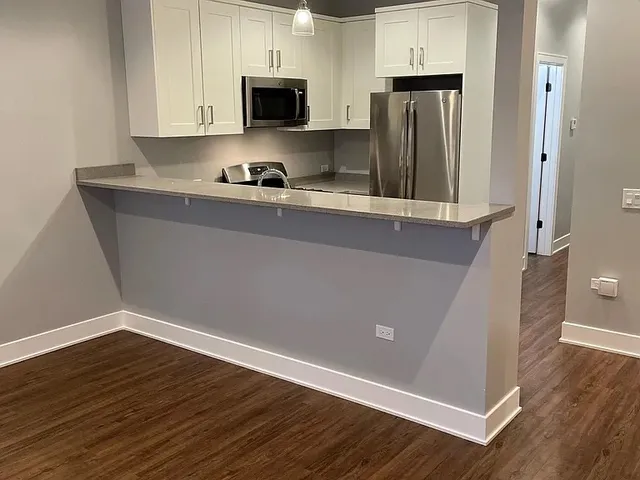 a kitchen with refrigerator and microwave