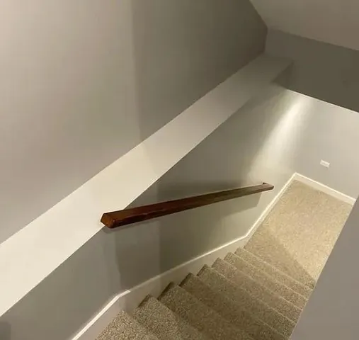 an empty room with wooden floor and mirror