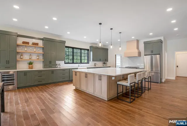 a kitchen with kitchen island granite countertop wooden floors and white cabinets