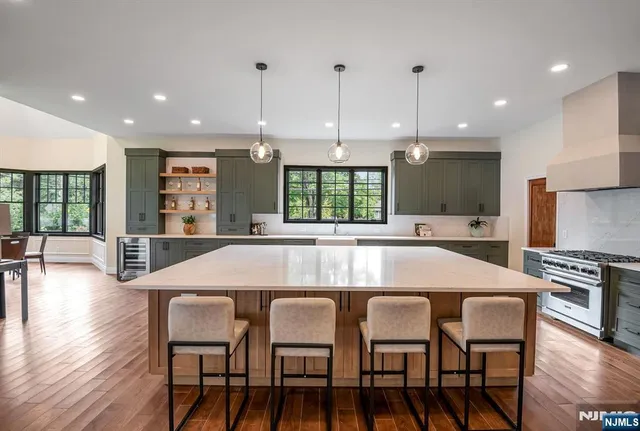 a kitchen with stainless steel appliances granite countertop a kitchen island a stove a table and chairs