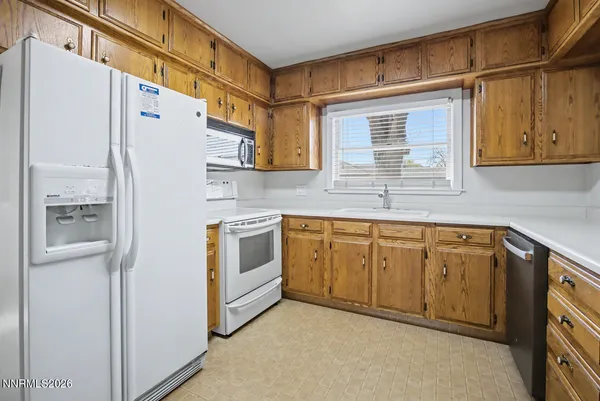 a kitchen with granite countertop cabinets stainless steel appliances and a sink