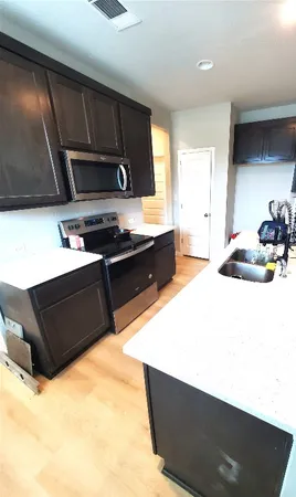 a kitchen with stainless steel appliances kitchen island granite countertop a sink stove and microwave