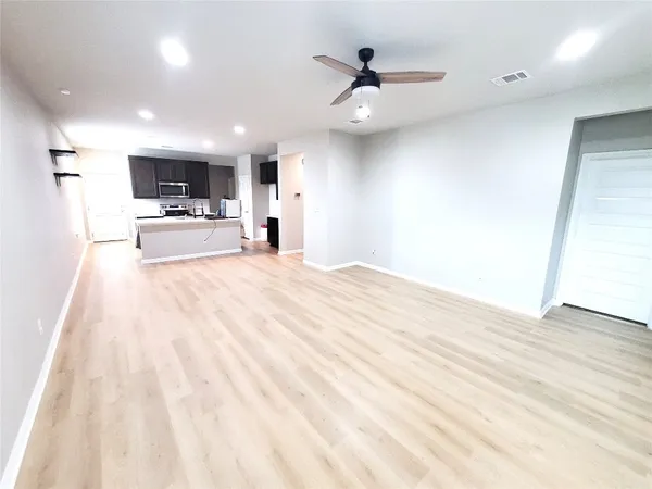 a view of a living room a kitchen and a wooden floor