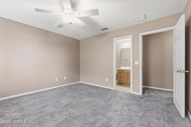a view of an empty room with a ceiling fan