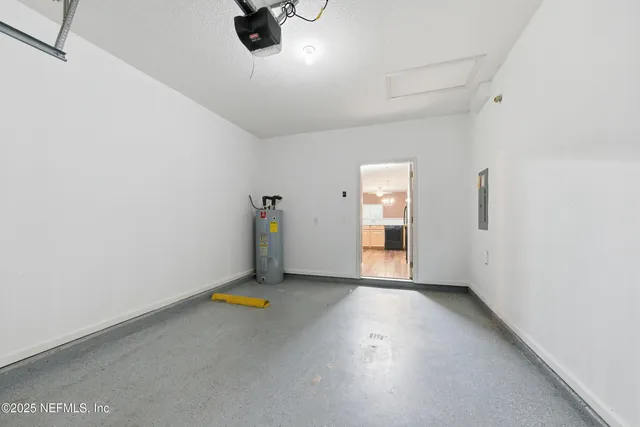 a view of an empty room with chandelier fan and windows