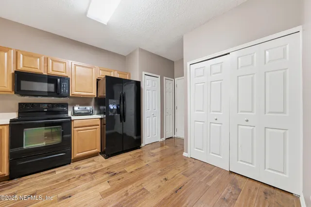 a kitchen with a refrigerator stove and wooden cabinets