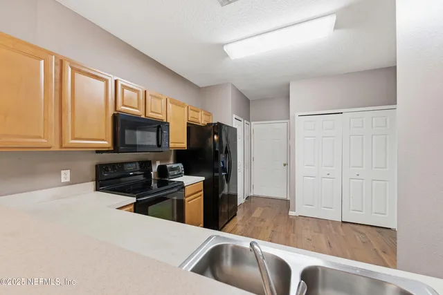 a kitchen with stainless steel appliances granite countertop a sink a stove and a refrigerator