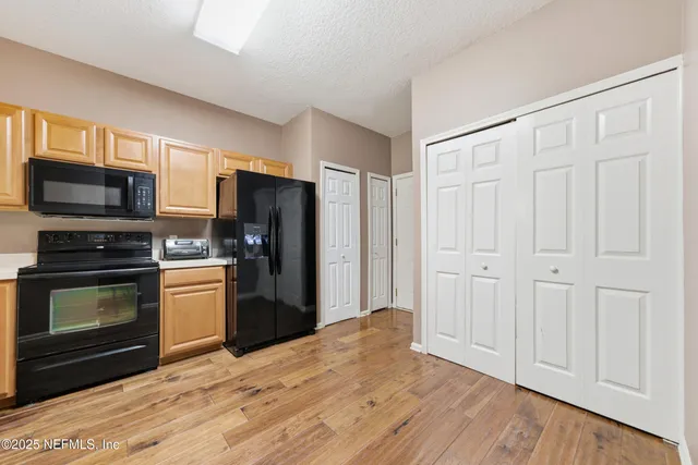 a kitchen with a refrigerator stove and wooden cabinets