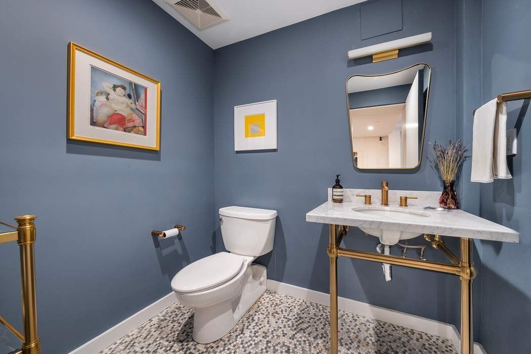 145 6th Avenue, Unit 5D Manhattan, NY 10013 - Photo 8 of 9 a view of a bathroom with a toilet sink and mirror