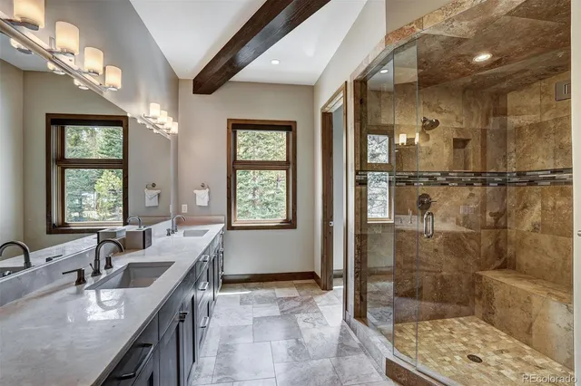 a bathroom with double vanity and a shower