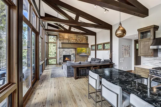 a kitchen with stainless steel appliances granite countertop a stove top oven a chimney cabinets and wooden floor