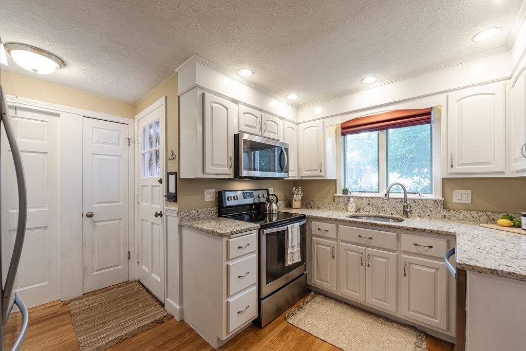 63 Maple Ridge Road Reading, MA 01867 - Photo 13 of 41 a kitchen with a sink stove and cabinets